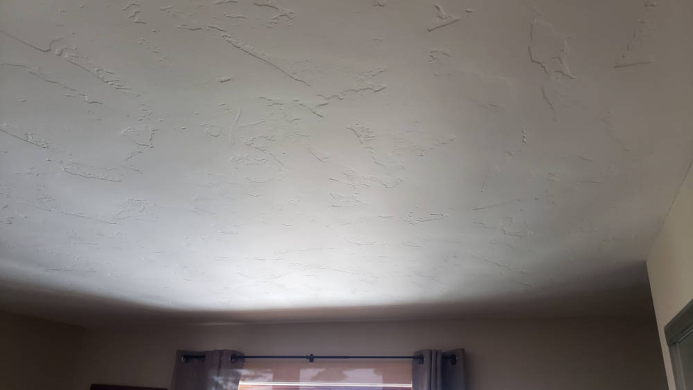 showing a ceiling after the popcorn texture removal, primed and painted.