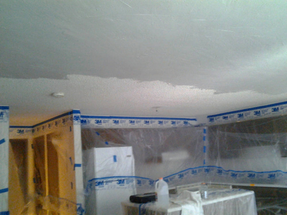 acoustical ceiling aka Popcorn Ceiling being covered with
					drywall compound.
