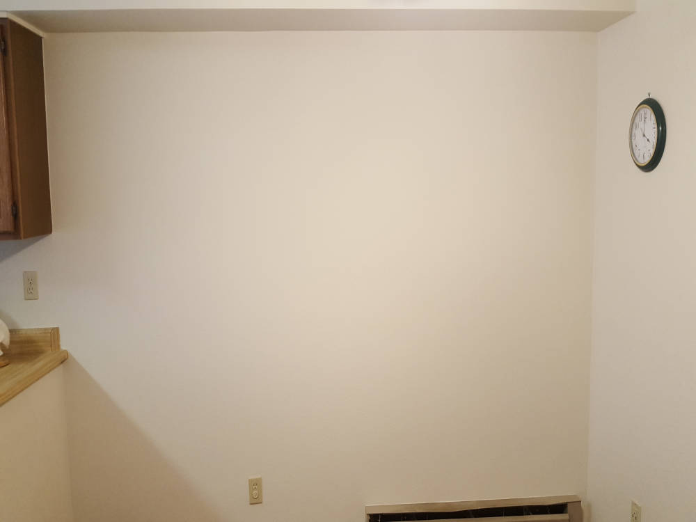 Wall after the drywall repairs, primer and paint are done.