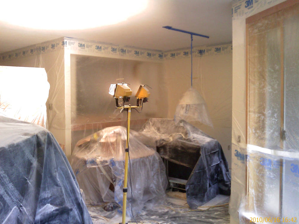 a leaving room covered with plastic ready for
					the drywall texture skip trowel.