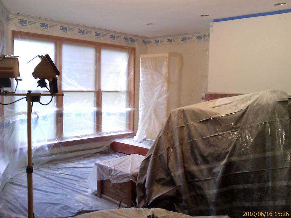 a leaving room covered with plastic ready for
					the custom drywall texture 