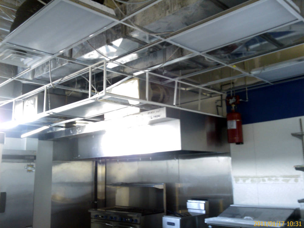 a kitchen in a restaurant showing the acoustical
					ceiling after installation.