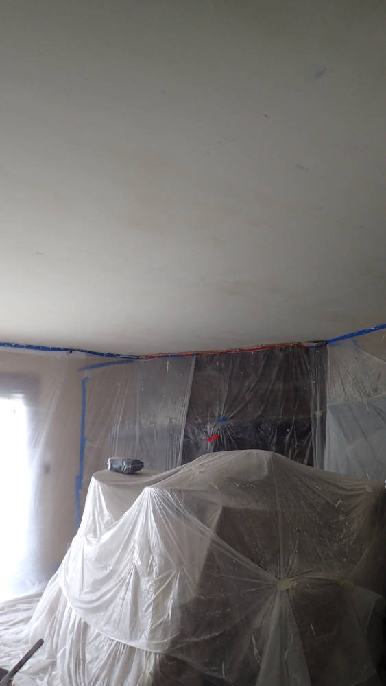 fireplace and couches completly protected with plastic during popcorn removal