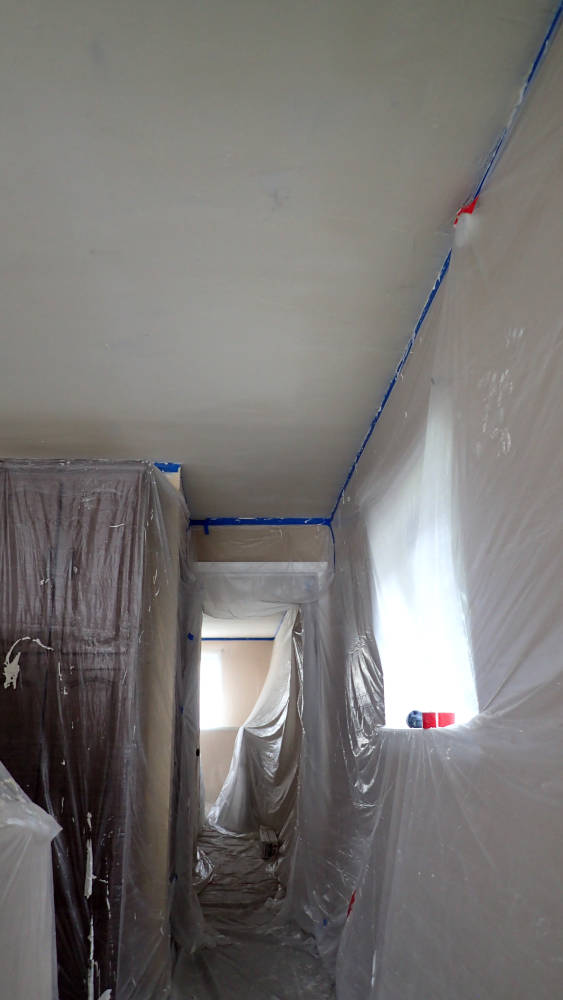 hallway completly covered with plastic, ready for popcorn ceiling removal