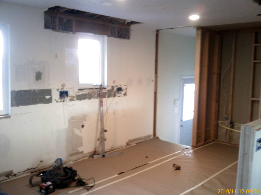 a kichen remodel showing some drywall holes where used 
					to be the cabinets and a new wall