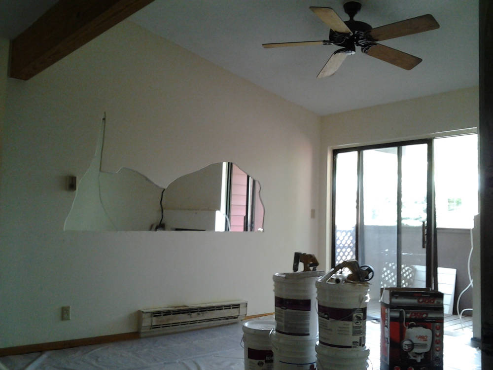 showing a leaving room with popcorn texture and a mirror inside the wall.